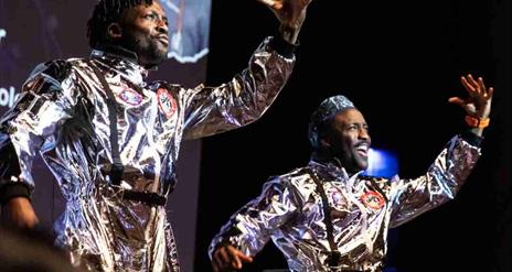 The O Twins dressed as astronauts stand side by side