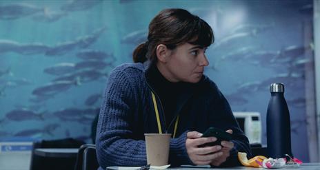 Woman sitting at table with phone