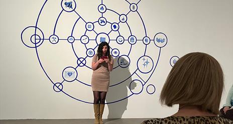 Woman stands in front of an audience reading