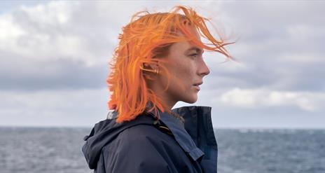 Woman with orange hair at the beach