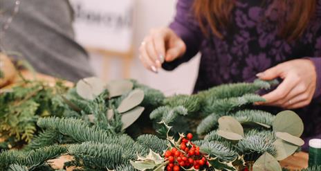 woman designing a pine centerpiece