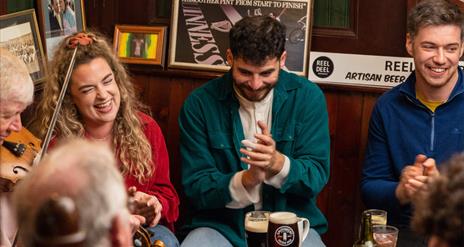 Group of people enjoying Irish music in a pub