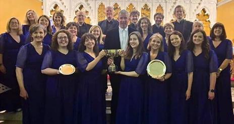 Image shows choir posing with awards in a group