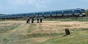 Golfers at Castlerock Golf Course as train passes