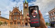 The Go Quest Adventures app on a phone with the Guildhall in the background.