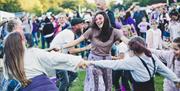 The family-friendly aspect of the event, with children and an adult holding hands in a circle.