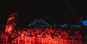 A lively scene from the festival of a performer in front of a crowd.