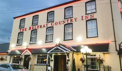 Exterior view of the Belfray Country Inn at night.