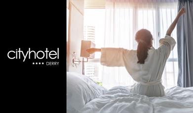 A person stretching in bed with the City Hotel logo.