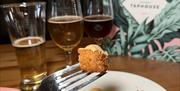 Arancini with three dope dick sample beers in the backgruond next to a Guildhall Taphouse menu