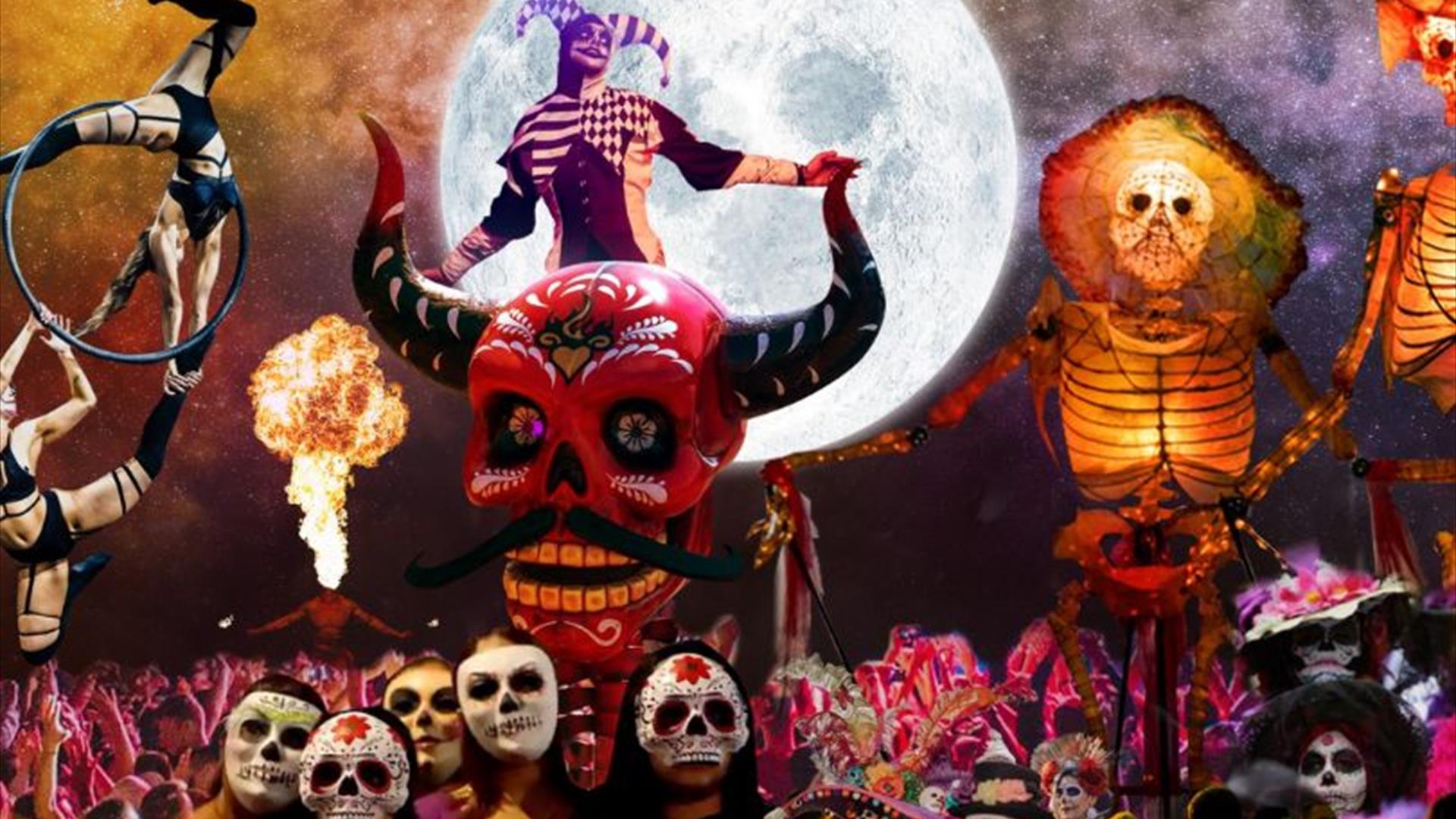An array of performers including acrobats, and dancers wearing sugar skull masks, amongst a vast crowd with their hands in the air. Background of a st