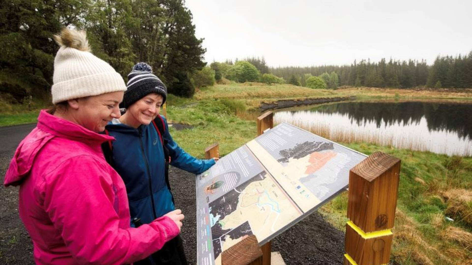 Visitors read information at the Killeter Forest Trails.