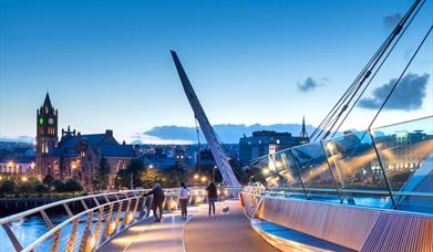 Image of a bridge at night leading towards the city's Guildhall