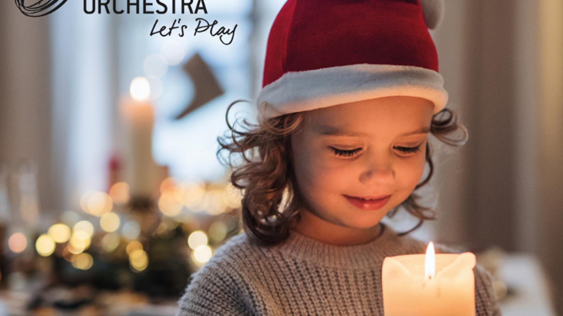 Child wearing a christmas hat and holding a candle