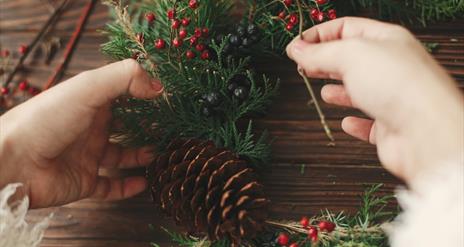 hands crafting a pine wreath