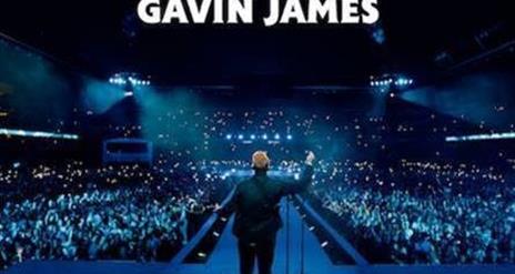 Gavin James facing a full arena, phone torches shining, blue mood lighting. White text above states 'Gavin James'.