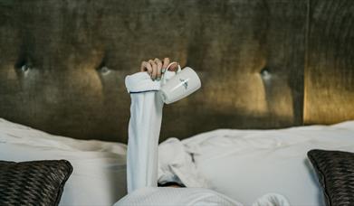 Promotional image for the 'Lazy Sunday' offer, showing an arm in a bath robe holding a cup.