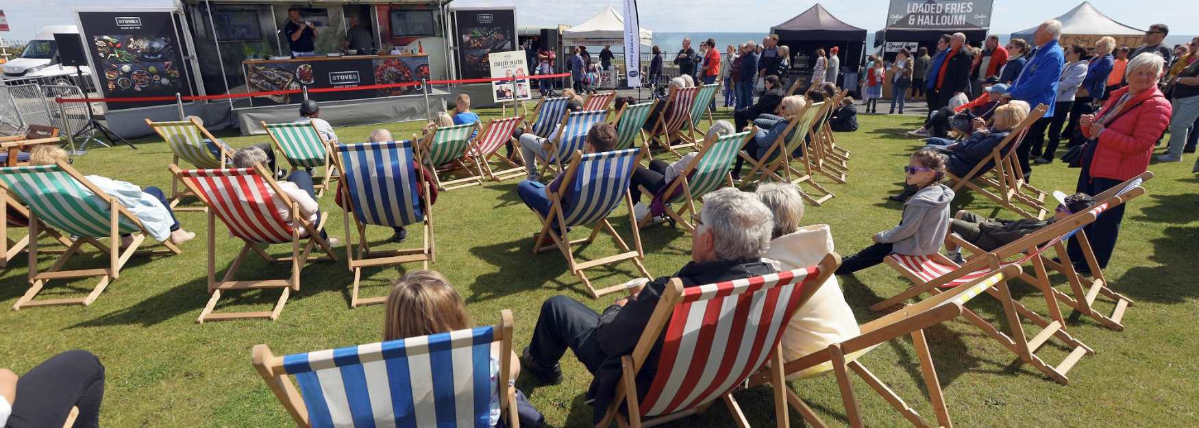 People sat on deckchairs watching a show