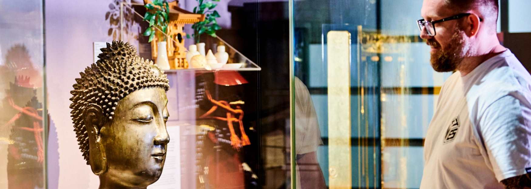 A man looking at a Budda head