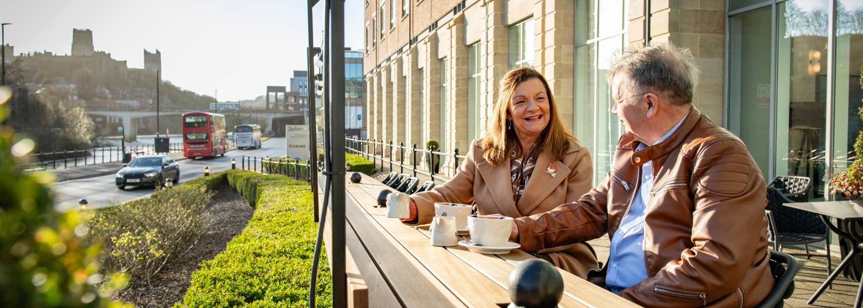 Two people having coffee outside of Radisson Blu Durham
