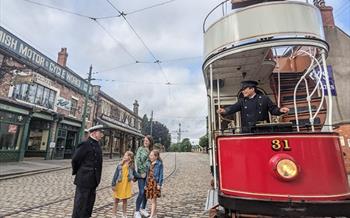 A family getting on a tram at Beamish