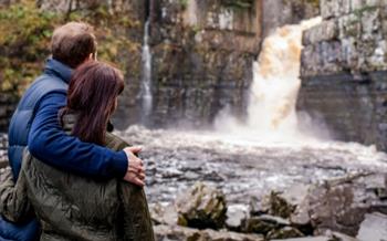 A couple looking at High Force waterfall