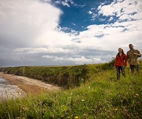 couple walking at Nose's Point on the Durham Heritage Coast 