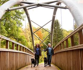 A mum and daughter walking their dogs at Hamsterley Forest