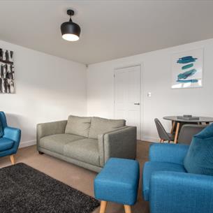 Living area with grey sofa and blue armchairs