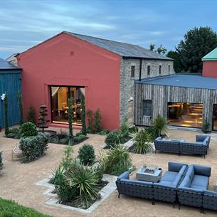 Exterior of Runa Farm with outdoor seating and shrubs