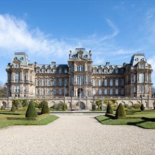 The exterior of The Bowes Museum and its grounds on a sunny day.