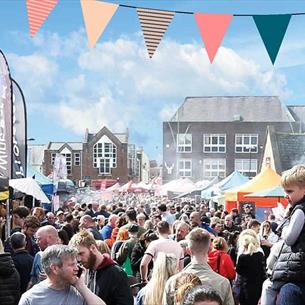 Crowds of people attending Bishop Auckland Food Festival, Market Stalls, bunting