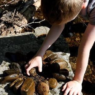 Boy making a design/pattern with rocks