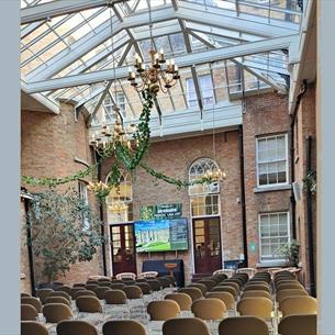 Glass ceiling room with chairs set out in Theatre style, screen