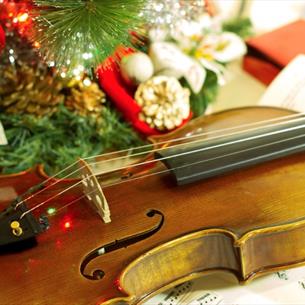 Violin, sheet music and Christmas decorations