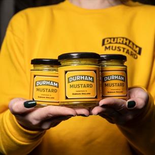 Holding 3 jars of Durham mustard in hands