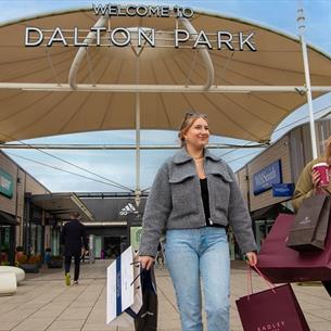 Shoppers leaving Dalton Park Outlet & Outdoors smiling. 