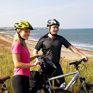 Two people on bikes at the coast