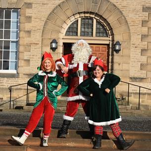 Santa and two elves outside of Ushaw