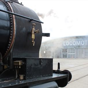 Steam train in front of the collections building at Locomotion