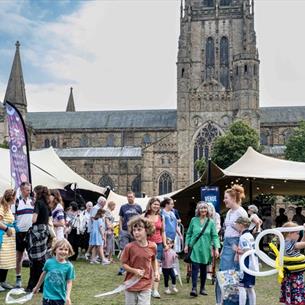 Crowds of people enjoying the Durham Fringe Festival on Palace Green, Durham city.