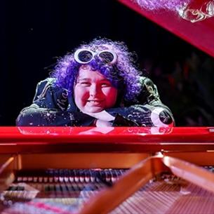 Amity sitting at a piano