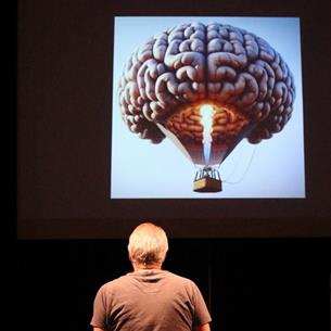 man looking at a hot air balloon in the shape of a brain