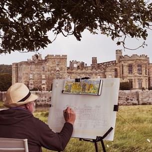 A man sitting and sketching Raby Castle