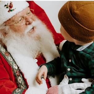 A small child sitting on Santa's knee