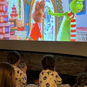Children watching a Christmas film on the big screen