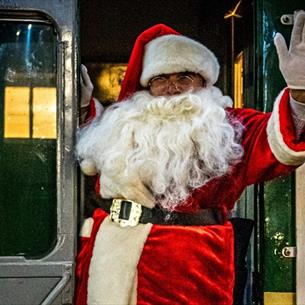 Santa greeting visitors aboard the Santa Express
