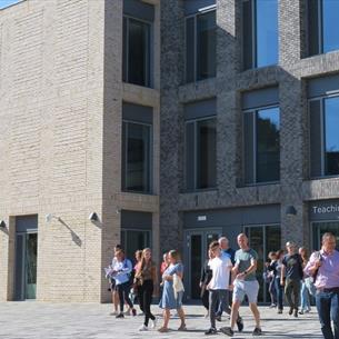 Exterior of Teaching and Learning Centre, people walking out of building.