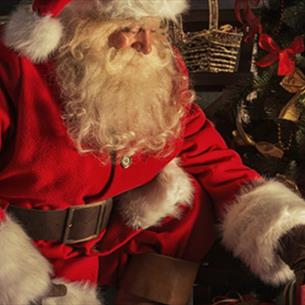 Santa placing presents under the tree.