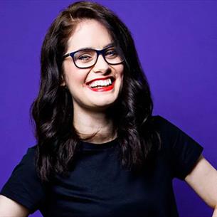Adele Cliff, with hands on hips, smiling. 